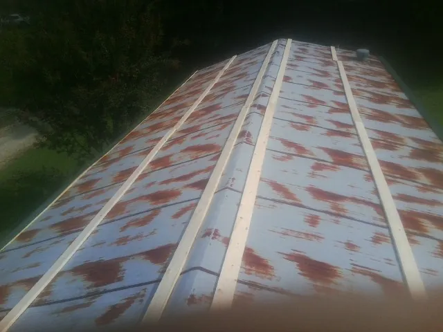 Rusted metal roof panels with new wood purlins before replacement — Storm Damage Roof Repair in Seville by Roofing Brothers