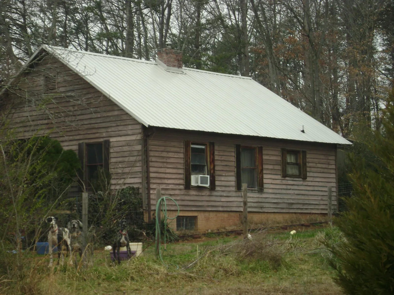 White metal roof on an old wood sided farmhouse, from a Metal Roof Installation job in Seville